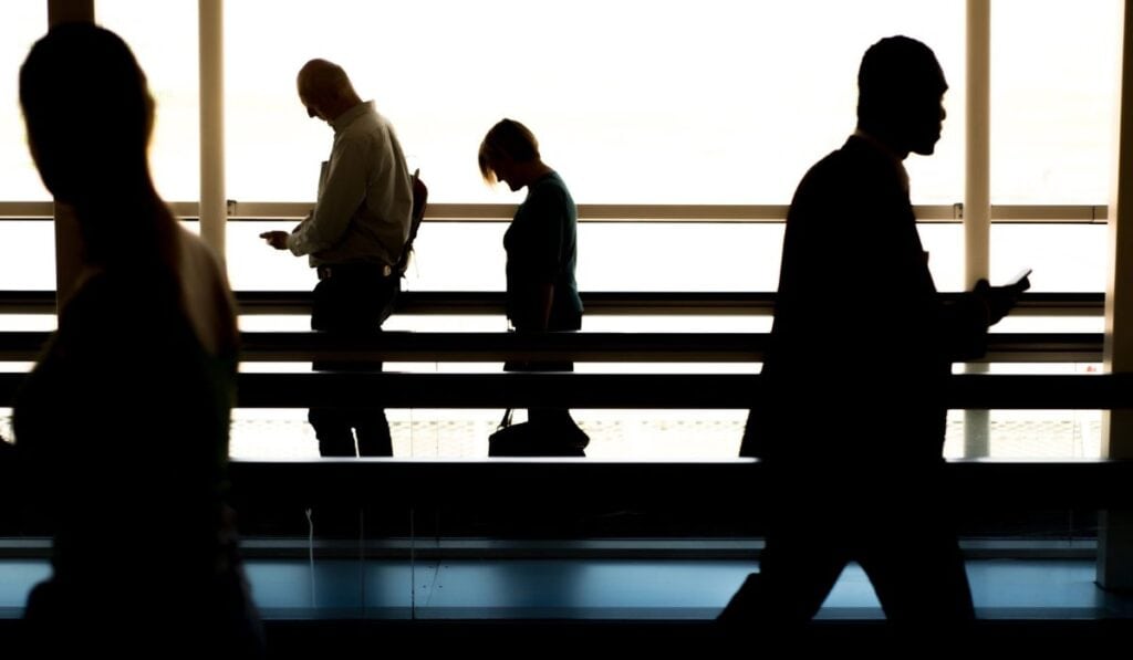 silhouettes of people walking in airport