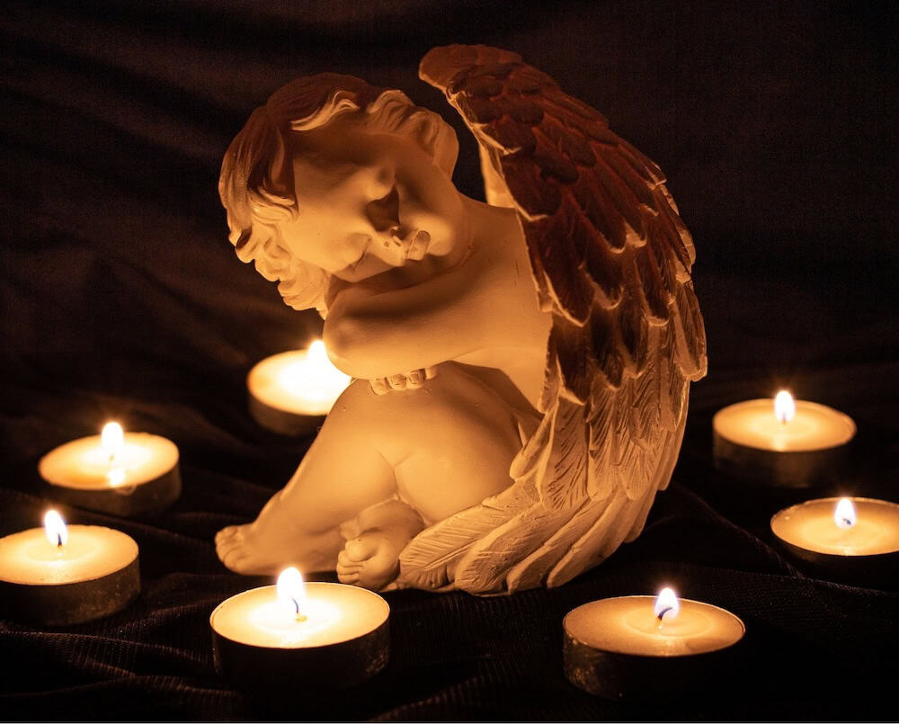 Angel statue with votive candles