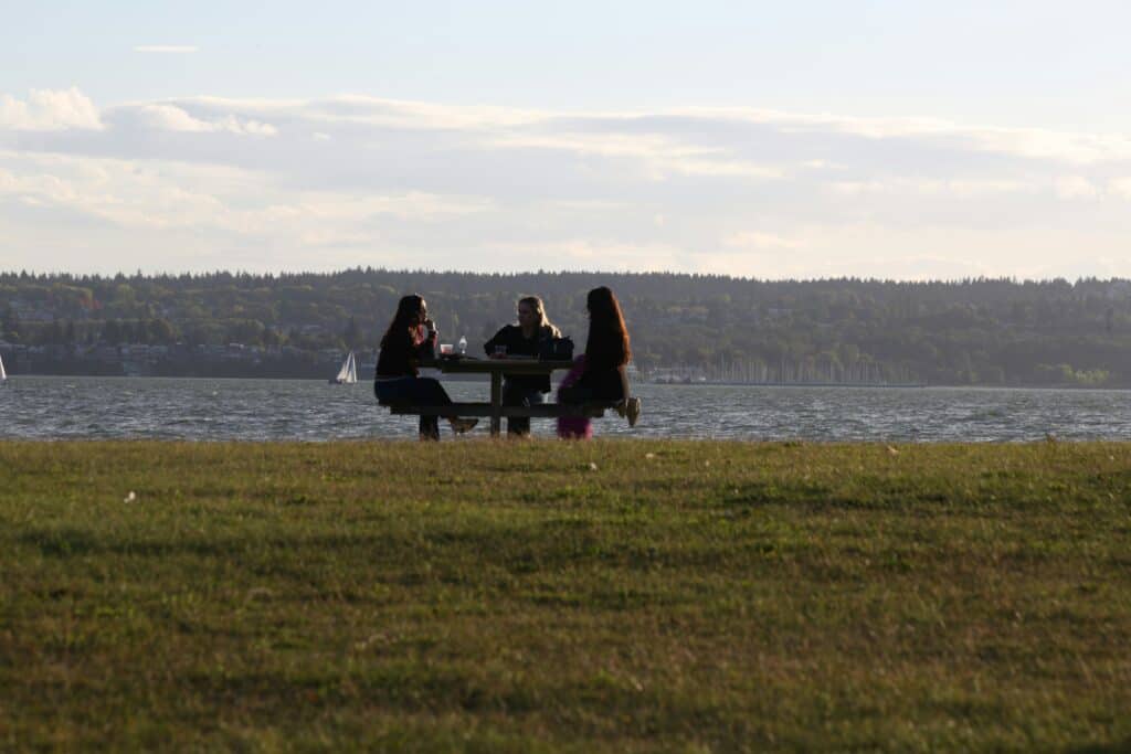 3 women talking by the ocean