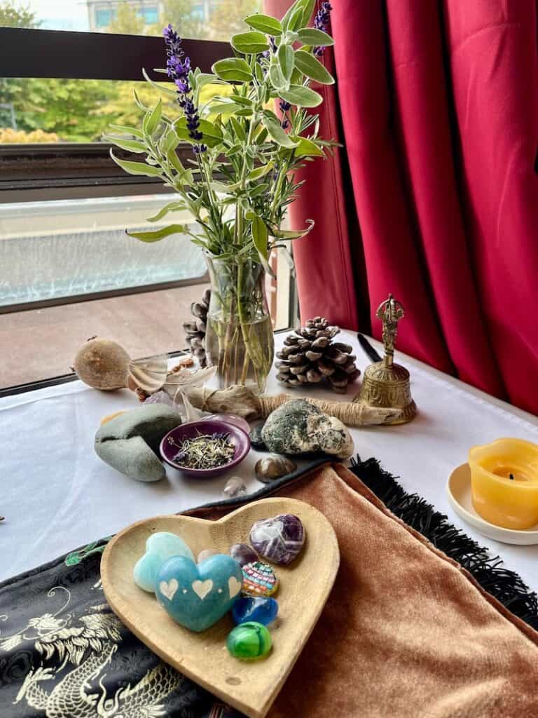 Death altar on table in window with hearts, stones and herbs